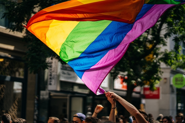 Bei einer Demonstration wird eine Regenbogenflagge geschwenkt.